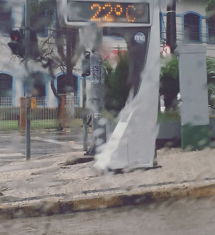 Termômetro de rua em canteiro central de via, marcando 22ºC