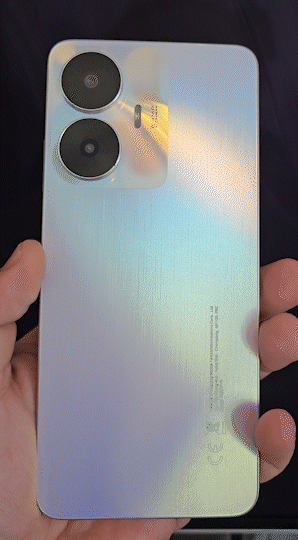 Realme C55 tem corpo em plástico, com acabamento que imita aço escovado e efeito furta-cor na traseira