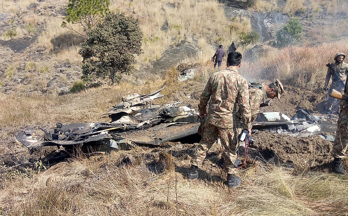 ￼SOLDADOS paquistaneses ao lado dos destroços de avião indiano que teria sido abatido (Foto: STR / AFP)