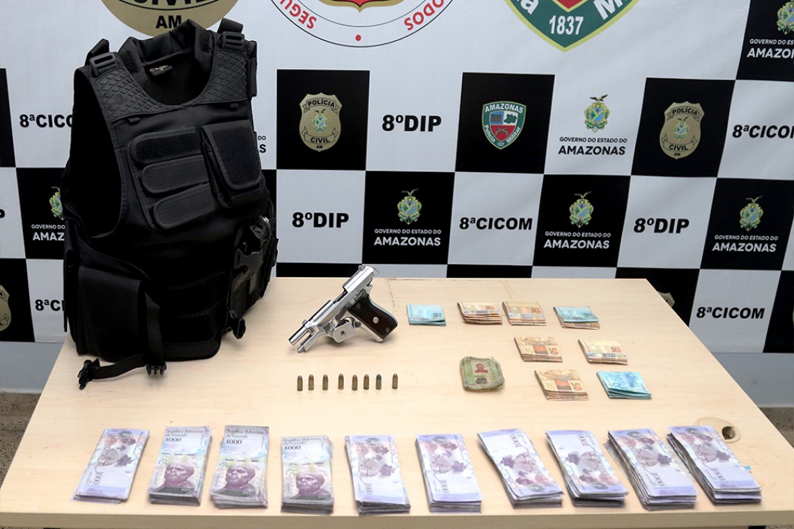 Com Carlos foram encontradas uma pistola 380, seis munições intactas, R$ 8 mil em espécie, quantidade expressiva de moedas estrangeiras e um colete balístico