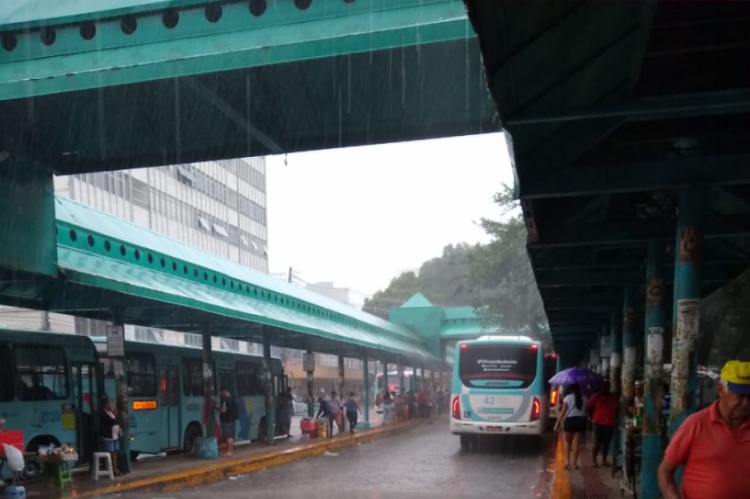 Passageiros se protegeram da chuva na praça Coração de Jesus nesta manhã.