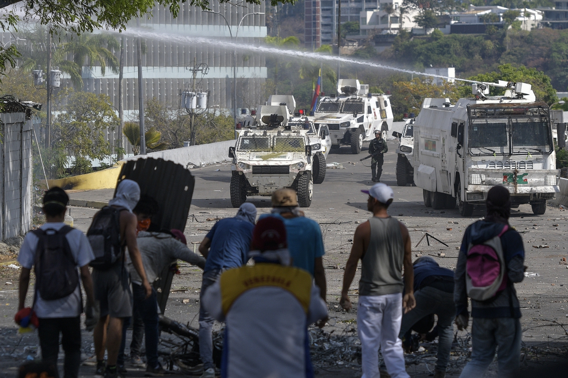 Anti-government protesters clash with security forces during the commemoration of May Day on May 1, 2019 after a day of violent clashes on the streets of the capital spurred by Venezuela's opposition leader Juan Guaido's call on the military to rise up against President Nicolas Maduro. - Guaido called for a massive May Day protest to increase the pressure on President Maduro. (Photo by Matias Delacroix / AFP) (Foto: Matias Delacroix/AFP)