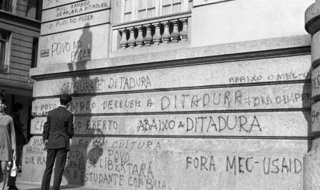 Em maios de 1968, homem lê a pixação de protesto na fachada do prédio 