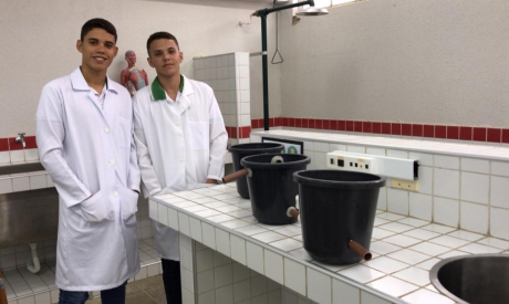 Neuclimar Júnior e Felipe Oliveira, estudantes do segundo ano do ensino médio, com os utensilios usados para transformar água poluída em potável 