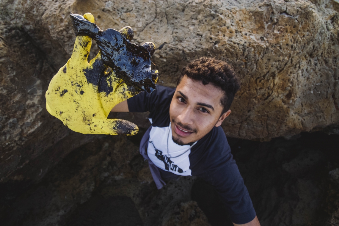 ￼VOLUNTÁRIO recolhe óleo da praia de Pontal de Maceió, em Fortim, no Litoral Leste do Estado (Foto: AURéLIO ALVES)
