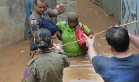 Policiais ajudam a resgatar vítimas em áreas alagadas em Minas Gerais. 