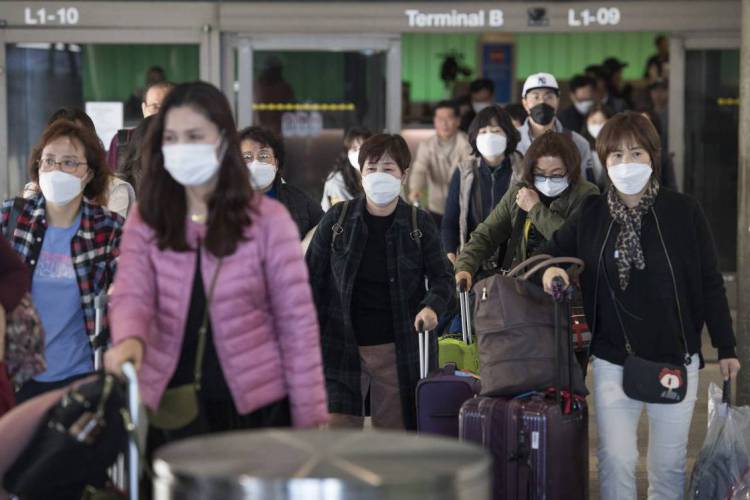 Passageiros chegam a cidade de Los Angeles, vindos da Asia, protegidos com mascaras, devido ao coronav&iacute;rus
