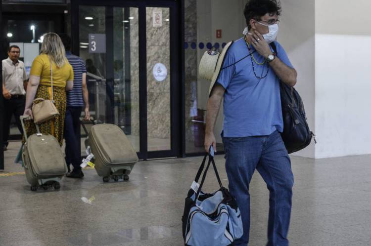 Movimentação de voos internacionais e domésticos após confirmação de caso de coronavírus no Brasil. Em destaque, pessoas com malas e máscaras no Aeroporto Internacional de Fortaleza