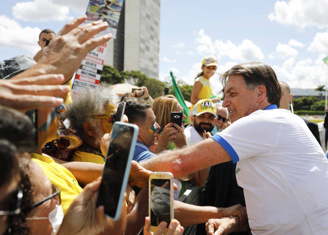 Sob suspeita de coronavirus, Bolsonaro cumprimenta apoiadores em frente ao Palácio do Planalto, após um protesto contra o Congresso e STF (Foto: Sergio LIMA / AFP). (Foto: Sergio LIMA / AFP)