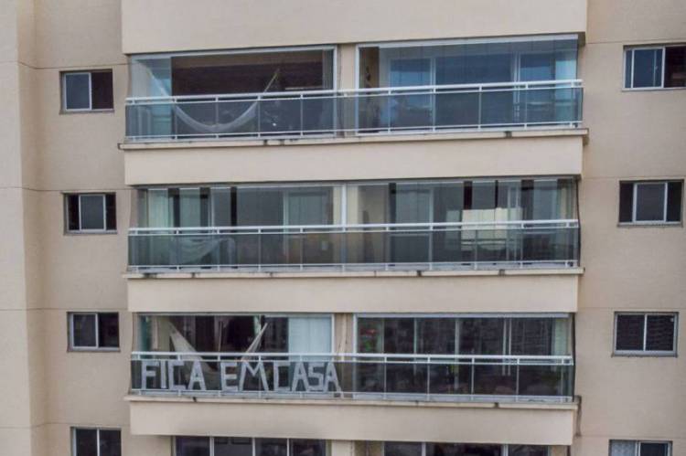 Fortaleza, Cear&aacute; Brasil 24.03.2020: Moradores confinados em seus apartamentos. Pr&eacute;dio exibe faixa de "fique em casa"