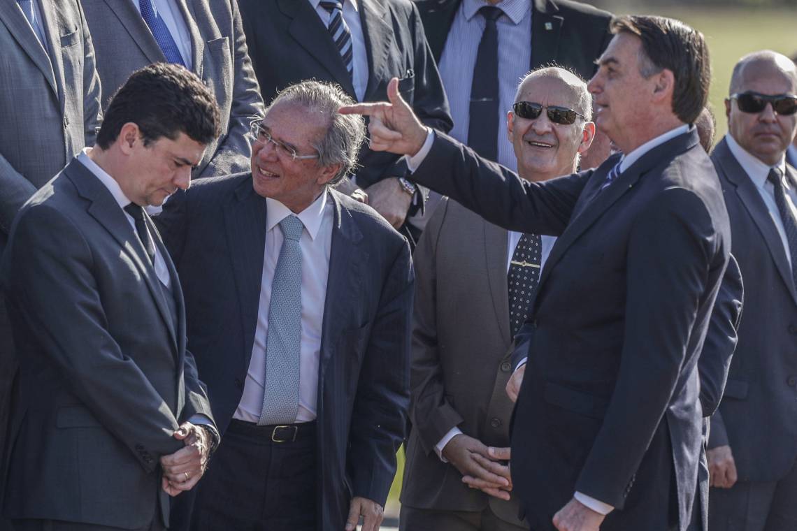 Bolsonaro aponta para Sergio Moro sob olhar de Paulo Guedes, quando ex-juiz era ministro (Foto: GABRIELA BILO/AE)