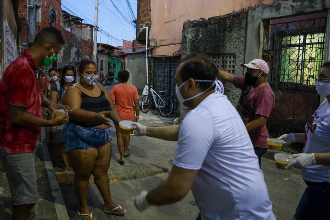 ￼ ROGER XIMENES, do grupo Unidos somos mais fortes, entrega sopa no bairro Bonsucesso  (Foto: FCO FONTENELE)