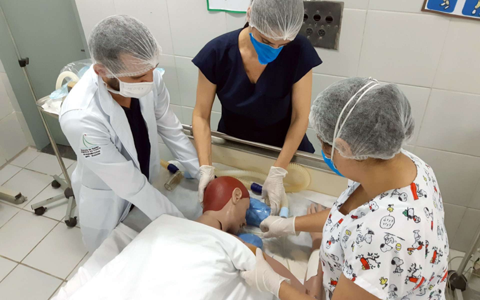 Residentes do Serviço de Terapia Ocupacional treinam técnicas em boneco que simula intubação  (Foto: Divulgação / Escola de Saúde Pública)
