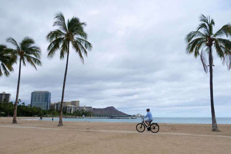 Um ciclista anda ao longo de uma praia vazia de Waikiki enquanto o furacão Douglas vira Oahu para o norte, poupando-o de um golpe direto, em Honolulu, Havaí, em 26 de julho de 2020