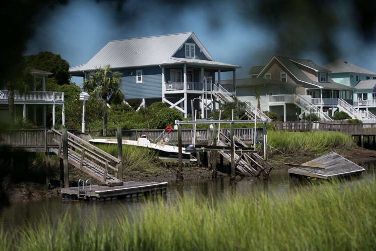 Um barco fica em terra perto de uma doca danificada após o surto de tempestade da noite anterior do furacão Isaias em 4 de agosto de 2020 em Holden Beach, Carolina do Norte