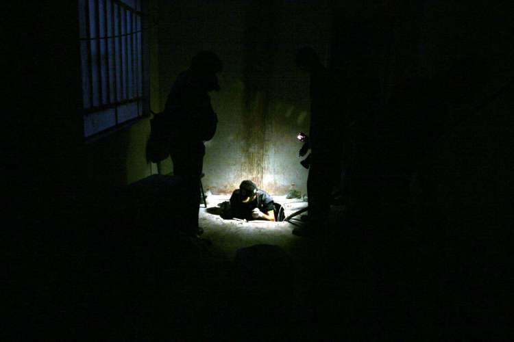 Policial federal examinando a boca do túnel escavado pela quadrilha para furto milionário à caixa-forte do Banco Central de Fortaleza. Crime foi descoberto na manhã do dia 8 de agosto de 2005