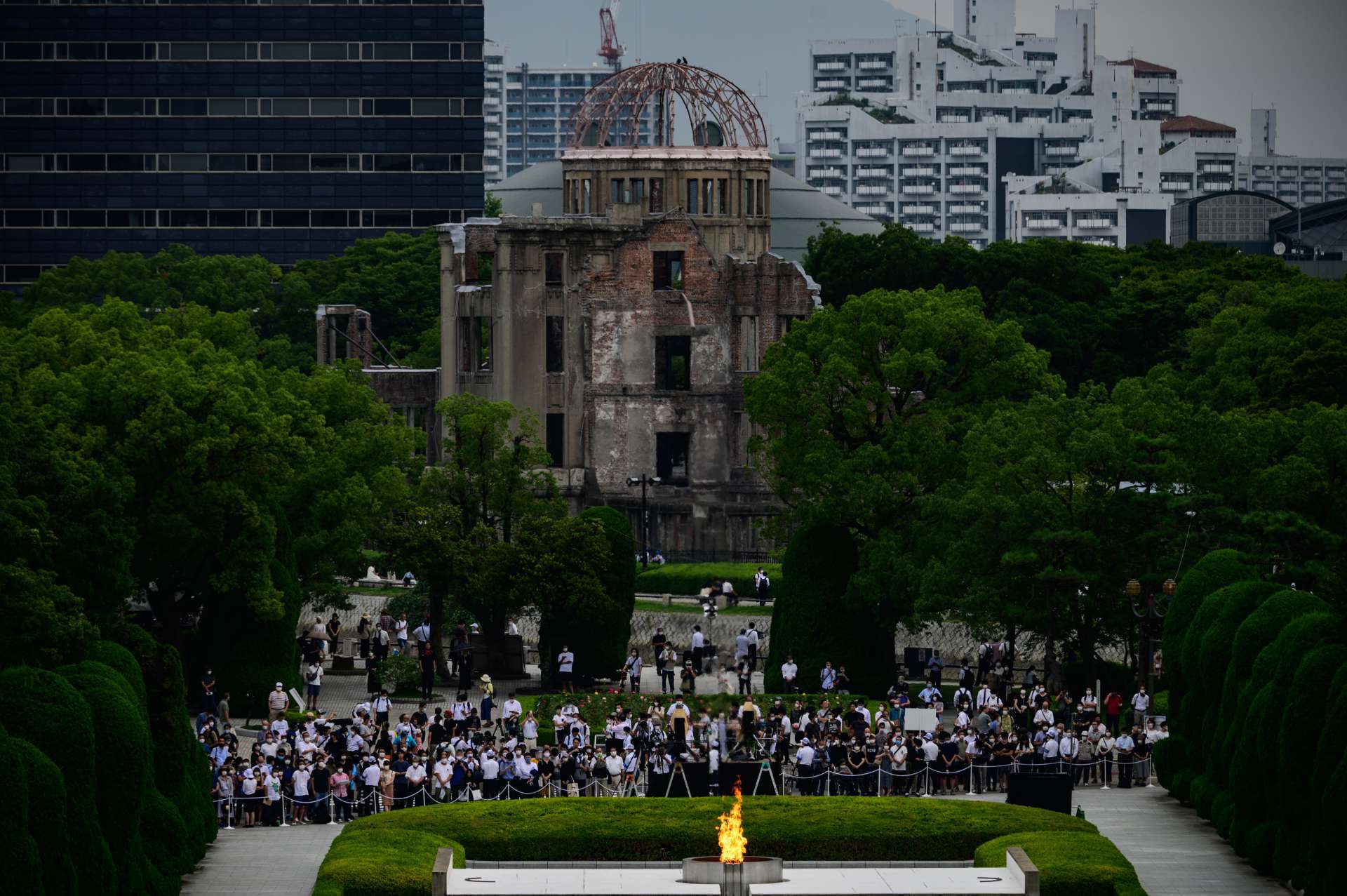 Pessoas e repórteres se reúnem em frente às ruínas do Salão de Promoção Industrial da Prefeitura de Hiroshima, agora conhecido como cúpula da bomba atômica (Foto: Philip FONG / AFP)