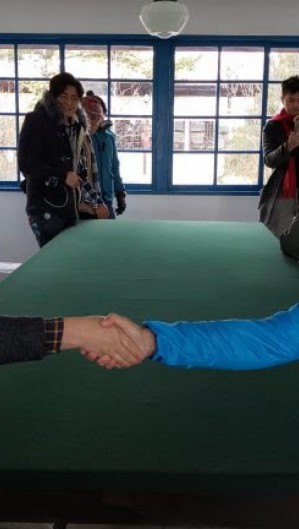 Mesma mesa onde foi assinado o armistício de paz. Leonardo Lopes está do lado da ONUl, enquanto o turista chinês está do lado da Coreia do Norte.
