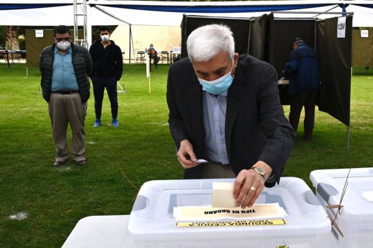 Um homem dá seu voto em um referendo constitucional nacional em uma assembleia de voto em Santiago, Chile, em 25 de outubro de 2020