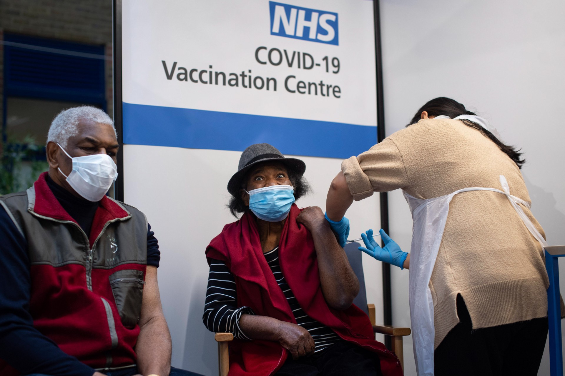 Londres, em 8 de dezembro de 2020. Lorna Lucas, 81, reage ao receber a primeira das duas vacinas Pfizer / BioNTech COVID-19 pouco antes de seu marido, Winston (L) também administrar uma no Guy's Hospital. - Grã-Bretanha em O dia 8 de dezembro marcou uma virada na luta contra a pandemia do coronavírus, ao iniciar o maior programa de vacinação da história do país com uma nova injeção de Covid-19. (Foto de Victoria Jones / POOL / AFP) (Foto: Victoria Jones / AFP)