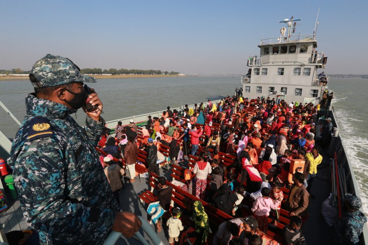 Refugiados Rohingya sentam-se em um navio da Marinha de Bangladesh enquanto são transferidos para a polêmica ilha sujeita a enchentes Bhashan Char na Baía de Bengala, em Chittagong