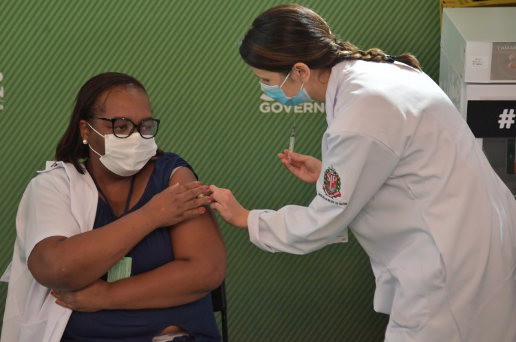 A enfermeira Monica Calazansis (C) é inoculada com a vacina CoronaVac Sinovac Biotech contra o coronavírus COVID-19 enquanto o governador de São Paulo João Doria (L) observa no hospital de Clínicas em São Paulo, Brasil, em 17 de janeiro de 2021. - O regulador de saúde da Anvisa do Brasil deu aprovação emergencial em 17 de janeiro de 2021 para suas duas primeiras vacinas contra o coronavírus, enquanto o país se prepara para lançar uma campanha de inoculação em massa em meio a uma segunda onda epidêmica devastadora. Autorizou os disparos de Covishield da AstraZeneca e da Universidade de Oxford, bem como do CoronaVac da China, para uso no país onde o número de mortos de Covid-19 agora ultrapassa 209.000, anunciou a Anvisa. (Foto de NELSON ALMEIDA / AFP)..