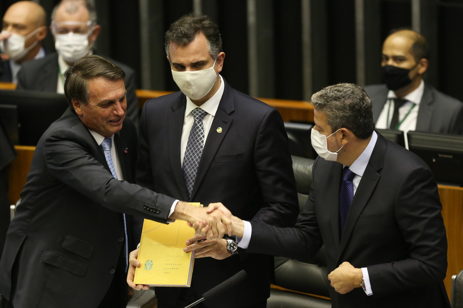 ￼Jair Bolsonaro cumprimenta Artur Lira (PP), presidente da Câmara, sob as vistas do senador Rodrigo Pacheco (DEM) (Foto: Fabio Rodrigues Pozzebom/Agência Brasil)