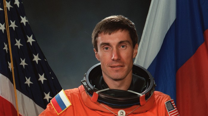  Krikalev com as bandeiras russa e estadunidense ao fundo, os países dos cosmonautas e dos astronautas