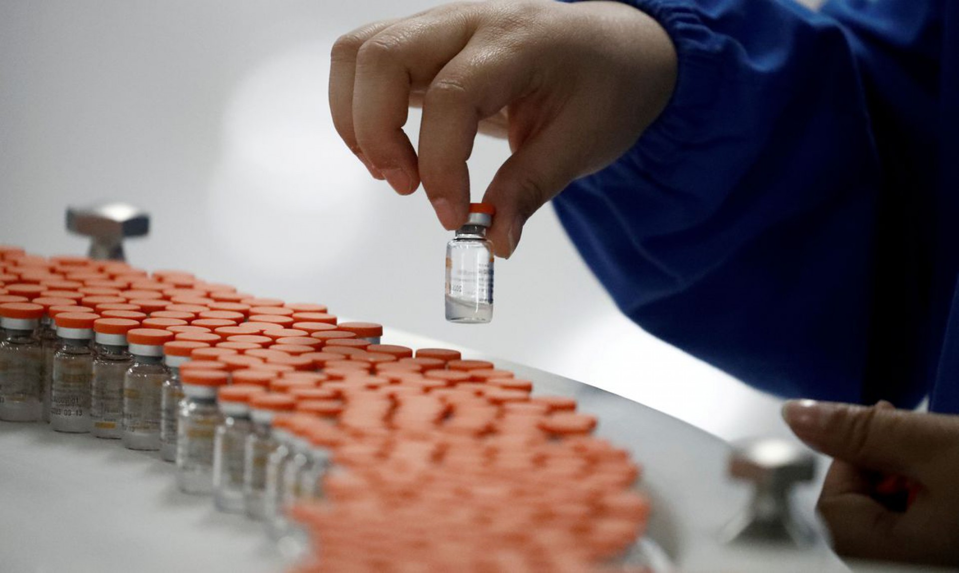 FILE PHOTO: A worker performs a quality check in the packaging facility of Chinese vaccine maker Sinovac Biotech, developing an experimental coronavirus disease (COVID-19) vaccine, during a government-organized media tour in Beijing, China, September 24, 2020. REUTERS/Thomas Peter/File Photo (Foto: REUTERS/Thomas Peter/File Photo)