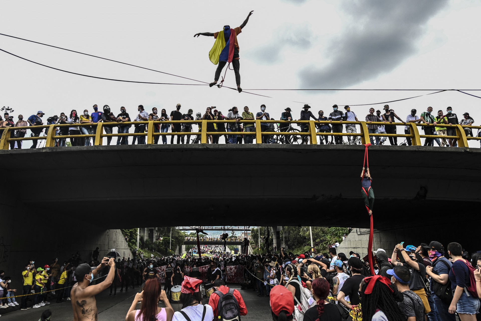 Demonstrators perform acrobatics during a protest against the tax reform launched by Colombian President Ivan Duque, in Medellin, on April 28, 2021. - Workers' unions, teachers, civil organizations, indigenous people and other sectors reject the project that is underway in the Congress, considering that it punishes the middle class and is inappropriate in the midst of the crisis unleashed by the COVID-19 pandemic. (Photo by JOAQUIN SARMIENTO / AFP)
      Caption (Foto: AFP)