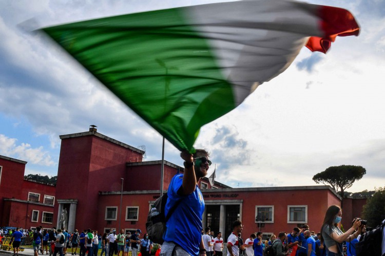Um torcedor da Itália agita a bandeira nacional ao chegar ao estádio olímpico em 11 de junho de 2021 em Roma, antes do início do jogo Turquia x Itália, na abertura do Campeonato Europeu de Futebol UEFA Euro 2020 2021. (Foto de Tiziana FABI / AFP)