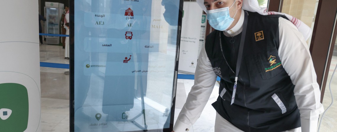 Um membro da equipe saudita digitaliza um cartão de hajj de peregrino, permitindo o acesso sem contato a locais religiosos, acomodação e transporte, em um centro de recepção em Meca em 18 de julho de 2021