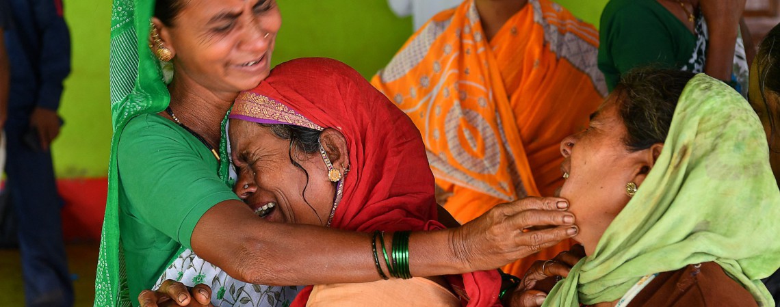 Aldeões consolam uma mulher que perdeu um parente após um deslizamento de terra em Taliye, a cerca de 22 km da cidade de Mahad, na Índia, em 24 de julho de 2021