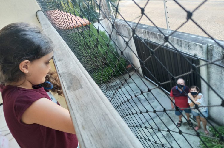 Maria Sofia, 7, observa os avós em uma das "visitas de varanda". Estratégia para driblar a saudade durante a pandemia de Covid-19. Abril, 2020.