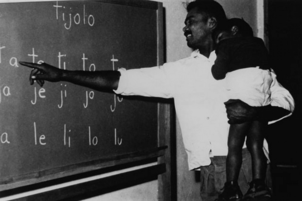 Angicos, 1963 - Educando com filha no colo, fazendo a identificação das sílabas (Foto: Acervo Paulo Freire)