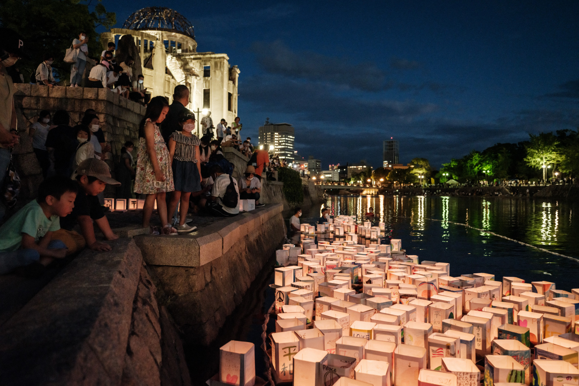 Membros da ONG local liberam lanternas de papel no rio Motoyasu em frente ao Hall de Promoção Industrial da Prefeitura de Hiroshima, como era conhecido antes de 1945, e agora chamado de Cúpula da Bomba Atômica, já que a cidade marca o 76º aniversário do primeiro ataque com bomba atômica do mundo, em 6 de agosto de 2021.. (Foto: YASUYOSHI CHIBA / AFP)