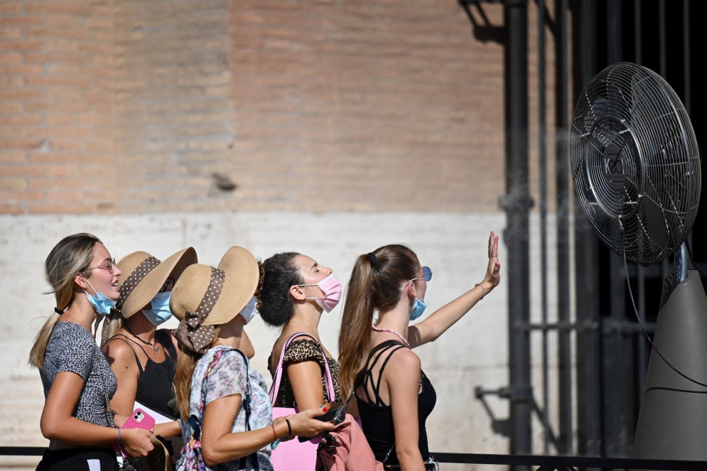 Um grupo de mulheres se refresca em frente a um ventilador durante uma onda de calor enquanto faz fila na entrada do Coliseu, em Roma(Foto: ALBERTO PIZZOLI / AFP)