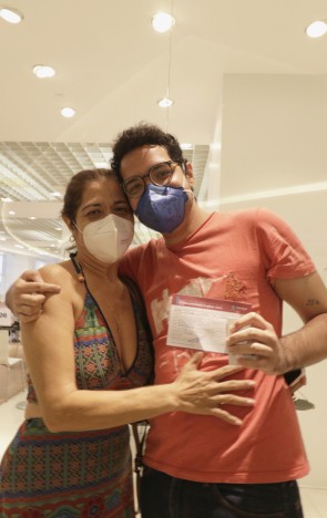 Estudante João Victor, 21, e sua mãe, Eugênia Costa, 50, comemoram a vacina do jovem