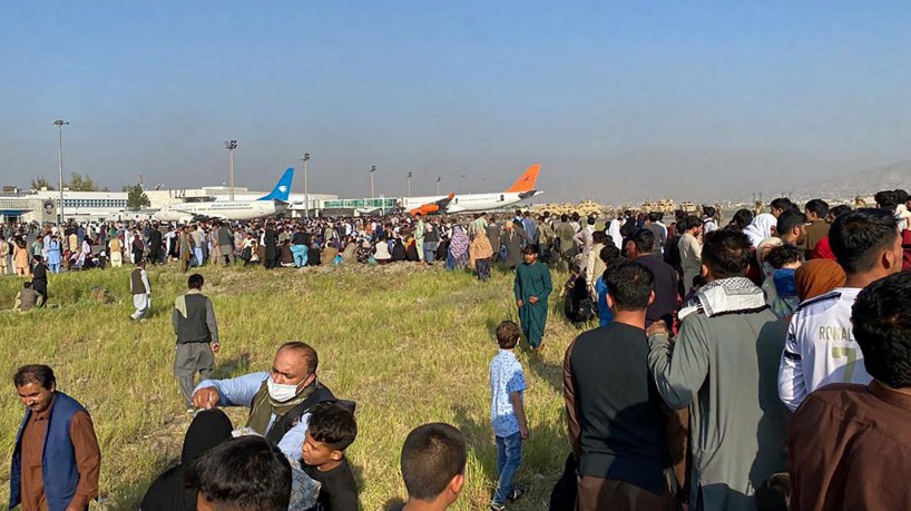 Afegãos e estrangeiros invadem pista do aeroporto de Cabul, capital do Afeganistão, buscando fugir da invasão do Talibã(foto: Shakib Rahmani / AFP)