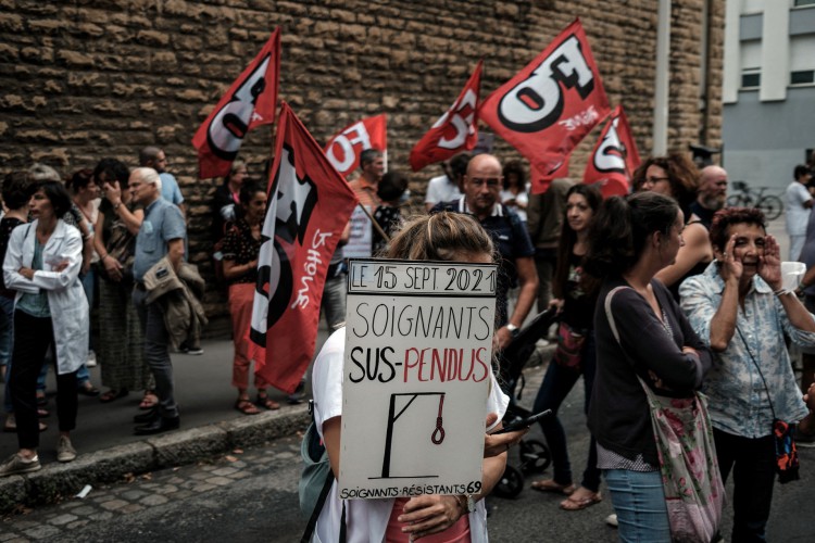 Um membro da equipe de enfermagem segura uma placa ao fazer uma demonstração em frente à ARS (agência regional de saúde) em Lyon, sudeste da França, em 14 de setembro de 2021, contra a obrigação de passaporte médico 