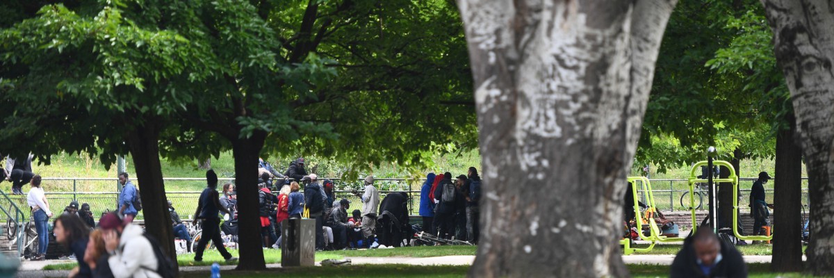 Pessoas sentam-se depois de serem realocadas perto da Porte de la Villette, norte de Paris, em 24 de setembro de 2021, após uma operação policial para expulsar usuários de crack no distrito de jardins Eole