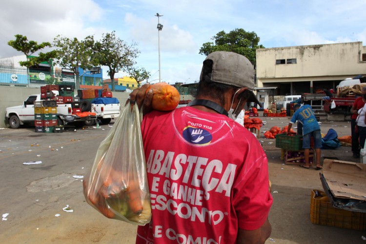 Homem recolhe sobras de frutas em pátio do Mercado São Sebastião(Foto: FABIO LIMA)