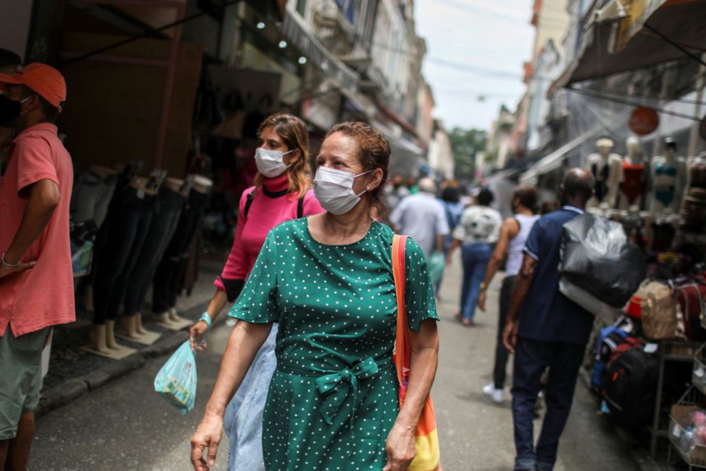 População teve de lidar com lockdown e máscara como método de controle na propagação do vírus(Foto: Reuters/Pilar Olivares/)