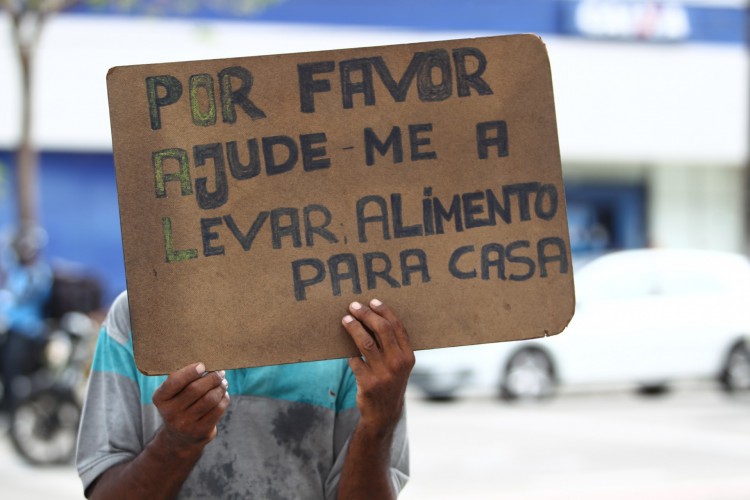Pessoas com cartazes pedindo ajuda nos sinais(Foto: FABIO LIMA)