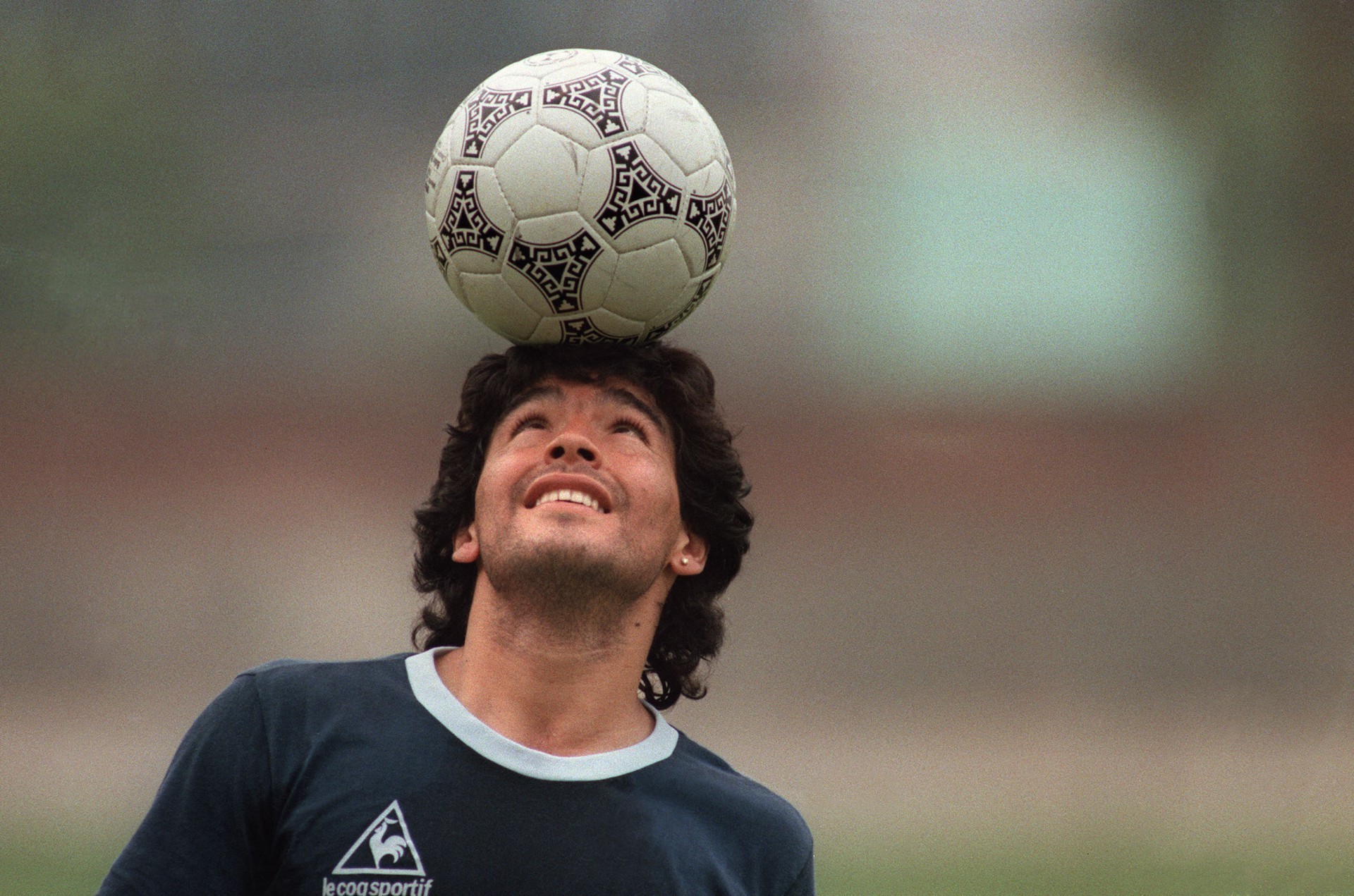 (FILES) In this file photo taken on May 22, 1986 Argentine soccer star Diego Maradona, wearing a diamond earring, balances a soccer ball on his head as he walks off the practice field following the national selection's 22 May 1986 practice session in Mexico City. - Next November 25, 2021 marks the first anniversary of Diego Maradona's death. (Photo by JORGE DURAN / AFP). (Foto: JORGE DURAN/AFP)