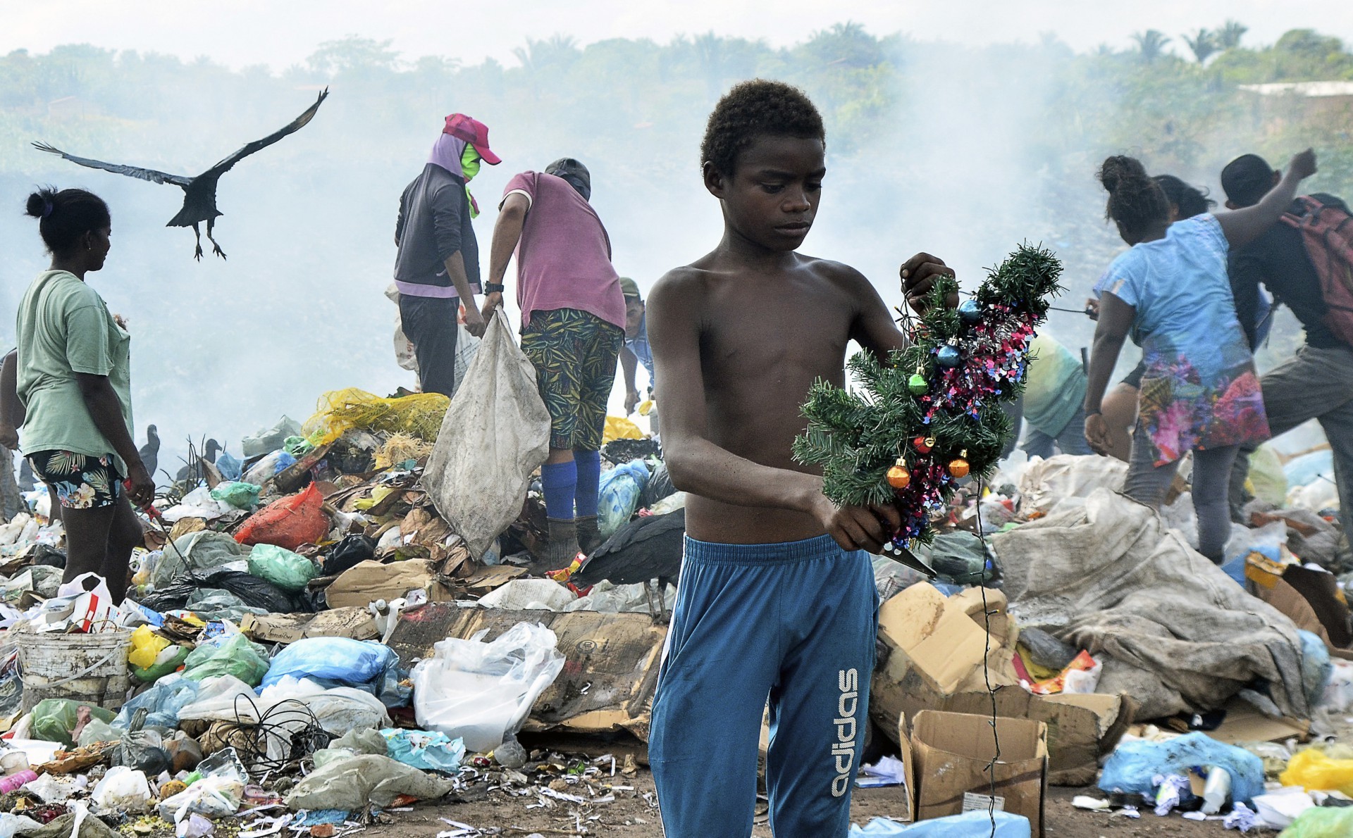Menino encontra uma árvore de Natal enquanto vasculha o lixo no aterro da Picarreira, bairro Cidade das Águas, em Pinheiro, Maranhão, Brasil, em 08 de novembro de 2021.