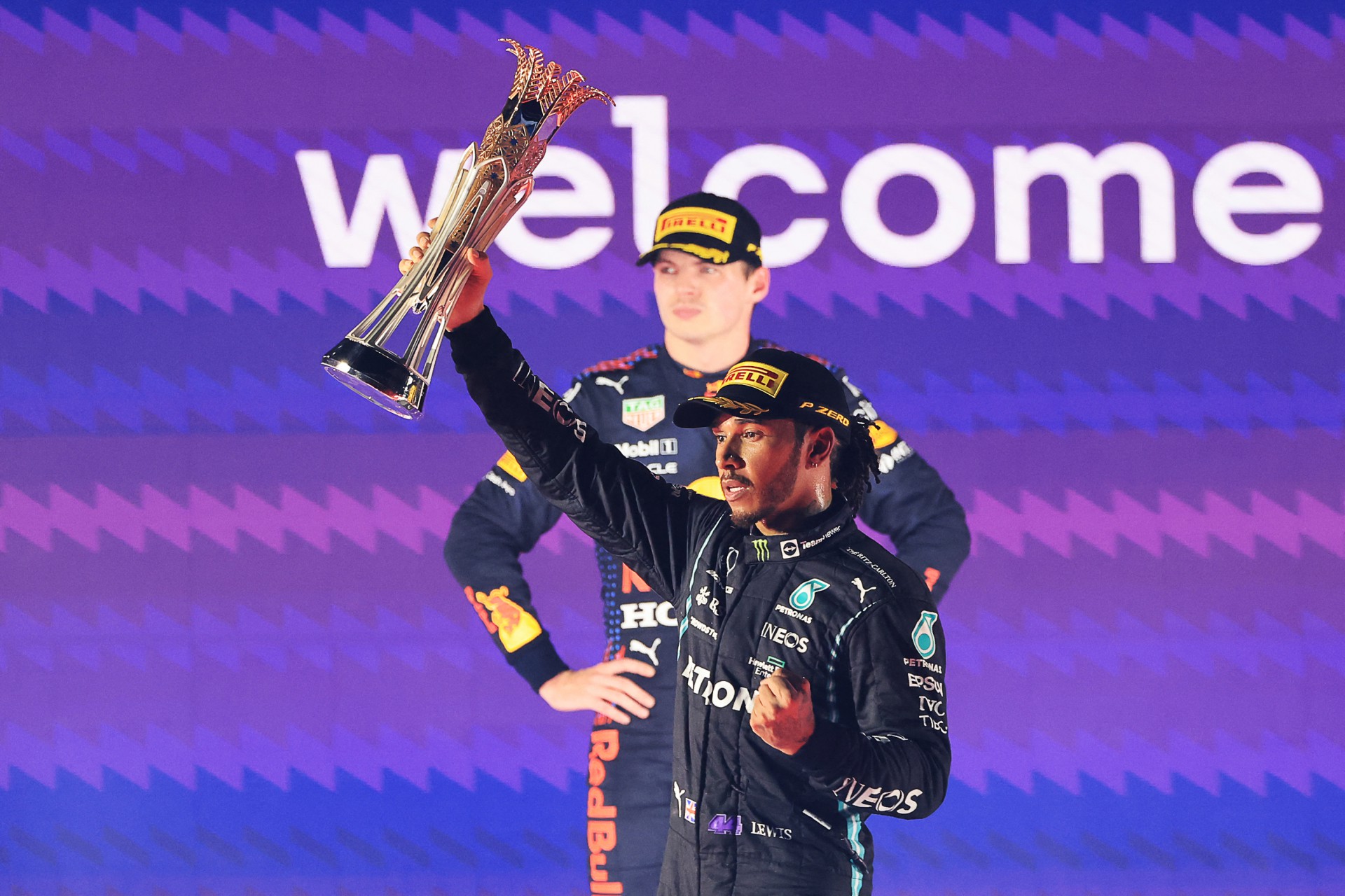 O vencedor da Mercedes, o piloto britânico Lewis Hamilton (R), reage com seu troféu flanqueado pelo segundo colocado holandês da Red Bull, Max Verstappen (L), durante a cerimônia do pódio após o Grande Prêmio da Arábia Saudita de Fórmula 1 no Jeddah Corniche Circuit em Jeddah em 5 de dezembro , 2021.
Foto Giuseppe CACACE / AFP (Foto: Giuseppe CACACE / AFP)