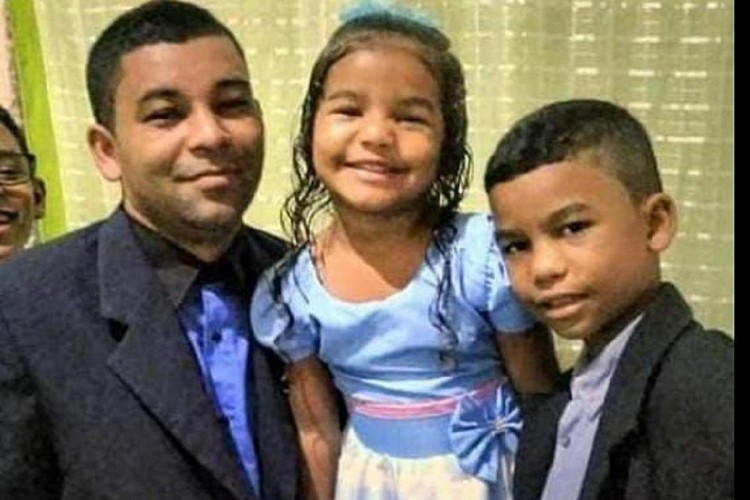 Crian&ccedil;as ao lado do pai, que sobreviveu &agrave; trag&eacute;dia 