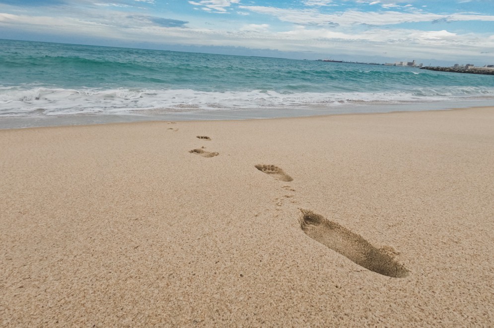 Imagem mostra marcas de pessoas no aterro da praia de Iracema junto ao mar(Foto: Júlio Caesar)