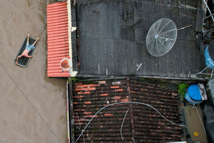 A man uses an inflatable mattress during flooding caused by the overflowing Cachoeira river in Itabuna, Bahia state, Brazil, December 26, 2021. Picture taken with a drone. REUTERS/Leonardo Benassatto  NO RESALES. NO ARCHIVES
     TPX IMAGES OF THE DAY     